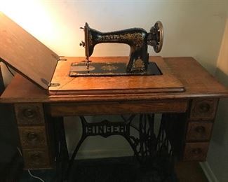 Singer sewing machine in oak cabinet
