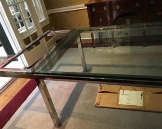 Detail: Vintage Milo Baughman style glass and polished stainless steel dining table with pull out extensions and 2 glass leaves, closed measures 6' by 42" wide and with two leaves for a 9' total.