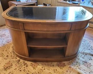 Backside of half circle shaped pecan finish wood & leather desk.