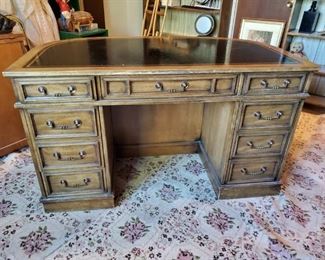 Front side of pecan finish wood & leather desk.