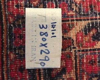 Original tag on back of area rug denotes that the rug was hand-woven in Iran.