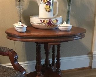 This four-footed, spindle-legged Walnut Victorian Lamp Table holds a Belgium Wash Bowl & Pitcher along with other complimentary pieces to the wash set.