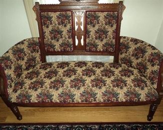 Elegant Eastlake Victorian Settee affords seating near a cheerful window.