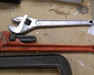 Rigid 24" pipe wrench, 18" adjustable wrench. Many more of these in smaller sizes hanging on the walls along with more that 12 hammers, mostly unused