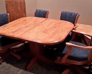 Oak table and 4 swivel chairs with casters, in excellent condition.