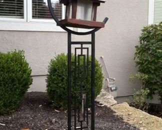 Large black metal yard art with hook for central hanging piece.