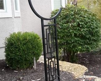 Large black metal yard art with hook for central hanging piece.