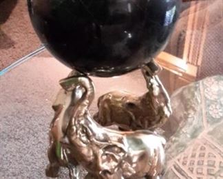 Solid brass elephants holding heavy, polished stone/marble sphere.