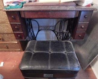 Antique sewing machine and storage ottoman.