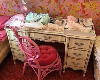 French Provincial desk; pink wicker chair.