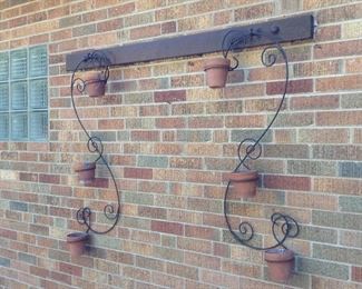 Two wrought iron flowerpot wall hangings.
