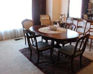 Cherry wood dining table with four chairs and a leaf