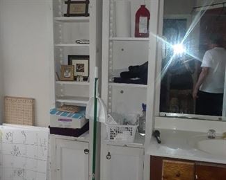 Narrow painted book or didplay shelving with adjustable feature on shelves, and with door below.