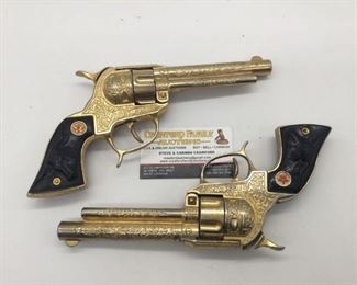 Lot 94 - Pair of RARE vintage Hubley gold tone Texan metal cap gun revolver pistols w/ black steer head