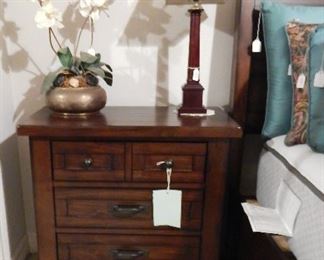 Matching bedside tables. They are two of the tables, lamps, and floral arrangements