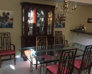 Nice glass, chrome, and brass mid century/Hollywood Regency dining table. Six chinoiserie style dining chairs.  Illuminated china cabinet by Broyhill. 