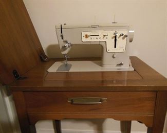Singer sewing machine with cabinet, and stool and manual and accessories.