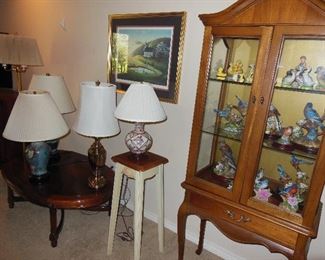Tall Queen Anne curio, beautiful oval coffee table, several decorator lamps, glimpse of just a few of the bird figurines collected.