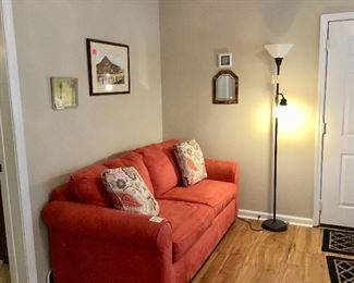 Front room with art, double light floor  lamp, pull out couch