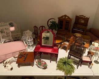 Lots of pieces of doll house furniture. 