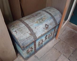 Antique hand painted hump back trunck, European. There are other similar antique pieces that will be under the tents on sale days.