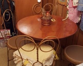 Art Nouveau ice cream parlor table and chairs, in excellent condition from the early 20th century. The wrought iron ice cream parlor table and four chairs have a wooden tabletop. Classic "spectacle" curving and twisted design.