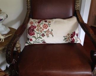One of two leather chairs with impressive detailing; embroidered pillow