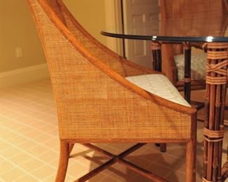 5 Barbara Barry for McGuire caned arm chairs in pecan finish; custom upholstery; McGuire bamboo and rawhide 5-leg table with beveled glass top