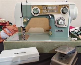 New Home sewing machine model 702 with accessories and assorted presser feet