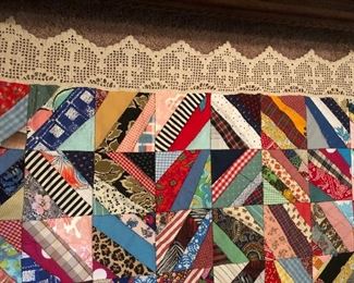 Scrappy strips table topper. Zigzag machine stitch. Crocheted border of crosses. Unlined back. 95” x 75”.