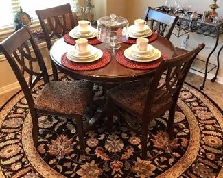 Mahogany round pedestal table with four upholstered chairs.