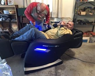 Exclusive Ft. Meigs Estate Sales Technicians testing the massage chair...confirming chair is in good operational condition.
