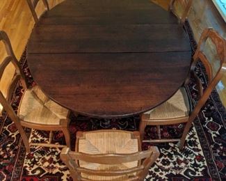 Bird's eye view of an antique, drop-leaf, barley twist dining table, with set of six French pecan side chairs, all atop a wonderful, hand woven Persian Heriz, measuring 8' x 10'.