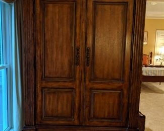 Big ol' burly wooden armoire, with flat screen TV and stereo component sound system within.