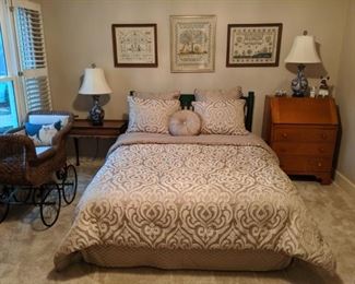 Queen size bed with fresh linens, 1940's mahogany side table with candle slides, vintage maple drop-down desk, pair of Asian porcelain table lamps, collection of hand stitched samplers and antique "Rosemary's Baby" pram.