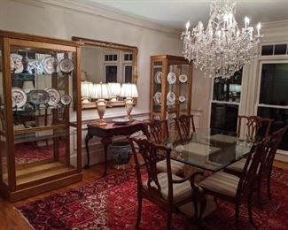 Nice, inviting dining room, with pair of Pulaski Furniture Co. lighted curio cabinets, pair of Italian Florentine table lamps, vintage beveled glass wall mirror, well-carved 1940's mahogany game table, glass-topped dining table, with set of six mahogany Chippendale chairs (2-arm, 4-sides) Maria Theresa 30 " wide, 2 -tier, 19-light crystal chandelier, all atop a fantastic, vintage Persian Heriz rug, measuring 9' x 13'.
