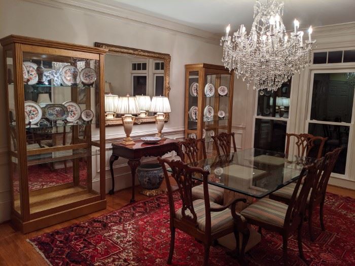 Nice, inviting dining room, with pair of Pulaski Furniture Co. lighted curio cabinets, pair of Italian Florentine table lamps, vintage beveled glass wall mirror, well-carved 1940's mahogany game table, glass-topped dining table, with set of six mahogany Chippendale chairs (2-arm, 4-sides) Maria Theresa 30 " wide, 2 -tier, 19-light crystal chandelier, all atop a fantastic, vintage Persian Heriz rug, measuring 9' x 13'.