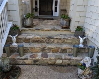 Nice entryway with galvanized tubs, filled with freshly planted butch pansies and violas, vintage concrete boy fountain, spaniel dog, pair of white, cast iron geese and pair of square shell concrete planters.