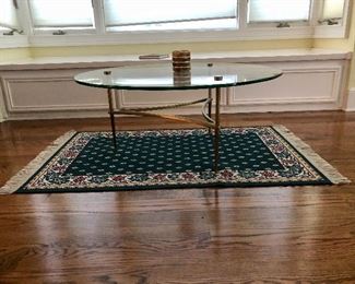 Mid century modern round glass top table  with heavy brass base, small rug