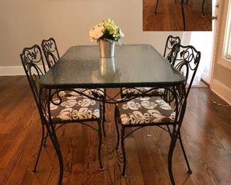 Wrought iron glass top table with four matching chairs