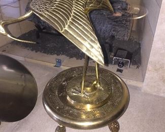 A brass decorative stand and bird