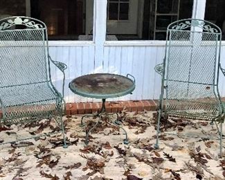 Two straight back metal chairs, round table