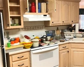 Kitchen full: Tupperware, cheese boards, vintage pot holders, knives, tea kettle, silverware...