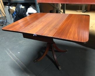 Wood dining table with two fold-down leafs.