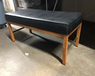Bench with black leather upholstered cushion.
