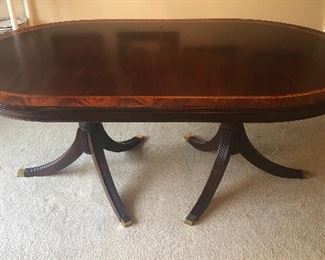 Henkel Harris mahogany double pedestal oval dining table with ribbon banding at edge (76"L, 46"W, 30"H). Extends to 124" with two 24" leaves in place (not shown) Includes table pads.