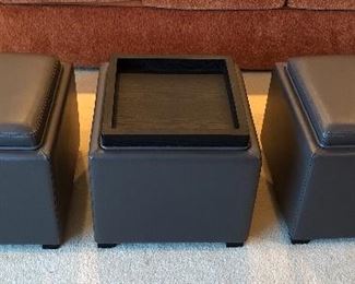 Crate & Barrel dark gray faux leather ottomans (storage cubes) Tops reverse to black wood tray. Each 18” x 18” x 17”H.