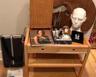 Art supplies: Soltek plein air easel (on floor), “The Soho” table easel & sketch box, Turtle Wood palette, brushes, “Planes of the Head” (artist’s mannequin head), wooden cart with wheels