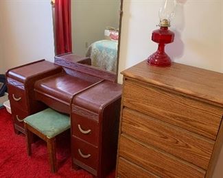 Make up vanity with stool four drawer chests and beautiful red oil lamp