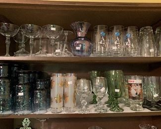 Large assortment of drinking glasses, including Holly Hobby and Norman Rockwell along with cut crystal